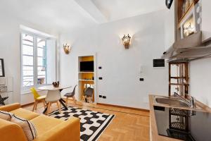 a kitchen and living room with a couch and a table at Aura Suites in Albenga