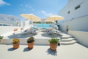 a patio with chairs and tables and umbrellas at Pantelia Suites in Fira