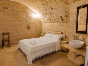 a bathroom with a bed and a sink in a room at Cave Rooms Sassi in Matera