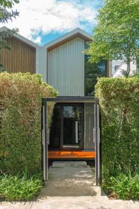 a house with an open door between two bushes at Gate43 Garden Villa in Lat Krabang