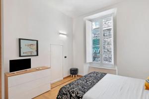 a bedroom with a bed and a tv and a window at Aura Suites in Albenga