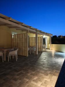 a large patio with chairs and tables at night at Case Vacanza il Sole in La Maddalena