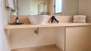 a bathroom counter with a sink and a mirror at Almarena Madero Urbano, Affiliated by Meliá in Buenos Aires