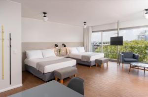 a hotel room with two beds and a balcony at Almarena Madero Urbano, Affiliated by Meliá in Buenos Aires