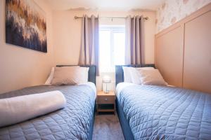 a bedroom with two beds and a window at Spacious Luxurious Serviced Accommodation 2 in Coventry