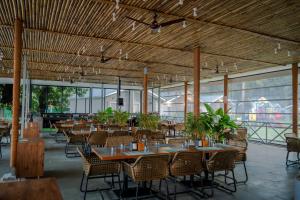 a restaurant with tables and chairs and windows at Trishvam Palolem Beach Resort in Canacona