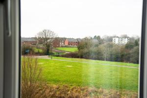 a view of a green field from a window at Spacious Luxurious Serviced Accommodation 2 in Coventry