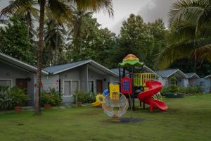 a playground in a yard next to a house at Trishvam Palolem Beach Resort in Canacona