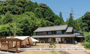 a house with a tent in front of a mountain at 本格貸切サウナの宿 つづやビレッジ in Minokamo