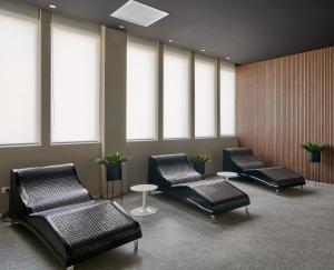 a waiting room with chairs and tables and windows at Almarena Puerto Retiro, Affiliated by Meliá in Buenos Aires