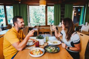 a man and woman sitting at a table eating food at Hotel Srdiečko in Tale
