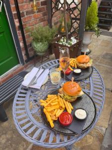 a table with two plates of food and french fries at The Cloud in Alderley Edge