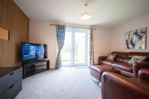 a living room with a couch and a television at Spacious Luxurious Serviced Accommodation 2 in Coventry