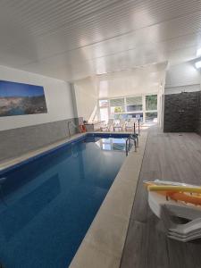a swimming pool in a house with a table and chairs at Apartamentos La Bodega in La Zarza