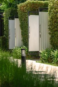 a row of mirrors in a garden with plants at Gate43 Garden Villa in Lat Krabang