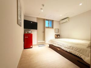 a bedroom with a bed and a red refrigerator at Namsan Forest in Myeongdong in Seoul
