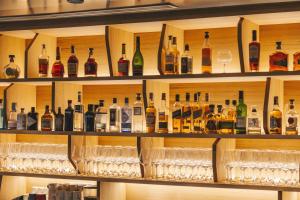 a shelf full of wine bottles and glasses at NH Collection San Sebastián Aranzazu in San Sebastián