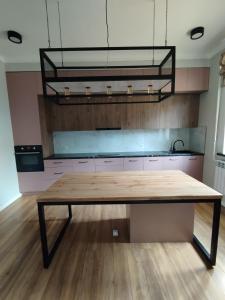 a kitchen with a wooden table in a room at Aziz House in Naryn