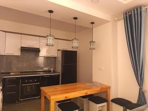 a kitchen with a wooden table and some lights at Nanik Hostel in Khorog