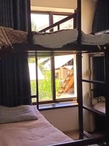 a bedroom with a bunk bed in front of a window at Nanik Hostel in Khorog +4 photos