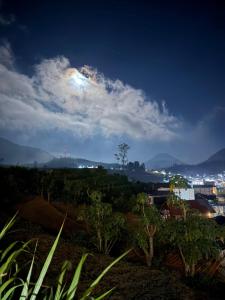 a view of a city at night with the moon at Oemah Ntuy Full view in Diyeng +4 photos