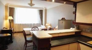 a hotel room with a kitchen and a bedroom at Kunming Hotel in Kunming