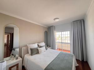 a bedroom with a bed and a large window at Casa do Rei - Charneca in Charneca +31 photos