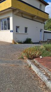 a white house with a curb next to a street at Le Relais des Ducs in Duras +3 photos