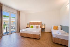 a bedroom with two beds and a balcony at Caladune Resort in Pizzo +57 photos