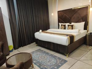 a bedroom with a large bed with a large headboard at Swiss Pearl Hotel Lahore in Lahore +31 photos