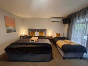a bedroom with two beds and a window at Mackenzie Motels in Fairlie