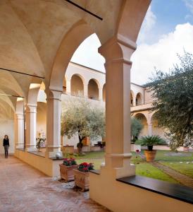 een vrouw die door een binnenplaats in een gebouw loopt bij Abbadia San Giorgio in Moneglia