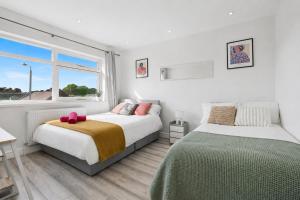 a bedroom with two beds and a window at K Suites - Nuxley Road in Bexley