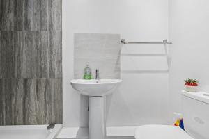 a white bathroom with a sink and a shower at K Suites - Nuxley Road in Bexley +23 photos