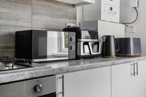 a microwave oven sitting on a counter in a kitchen at K Suites - Nuxley Road in Bexley