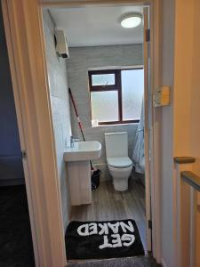 a bathroom with a sink and a toilet and a rug at The Chilux stylish apartment in Rainham