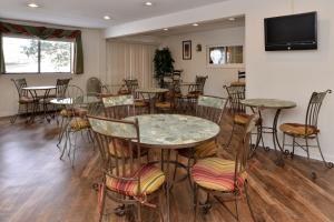 Habitación con mesas, sillas y TV de pantalla plana. en Americas Best Value Inn New Paltz, en New Paltz