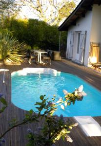una pequeña piscina azul en una terraza de madera en Villa Mogador Piscine et Balnéo, en Andernos-les-Bains