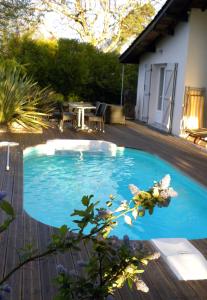 a small blue swimming pool on a wooden deck at Villa Mogador Piscine et Balnéo in Andernos-les-Bains