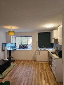an empty kitchen with a desk and a window at The Chilux stylish apartment in Rainham