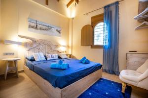 a bedroom with a bed with blue sheets and a chair at Nous Village 2 in Alyki +119 photos