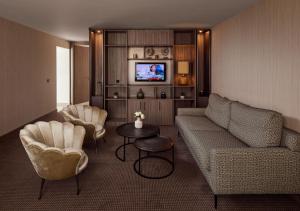 a living room with a couch and chairs and a tv at Van der Valk Hotel Nuland - 's-Hertogenbosch in Nuland
