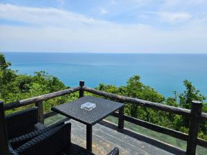 a table and two chairs on a balcony with the ocean at Phangan Utopia Resort in Mae Haad