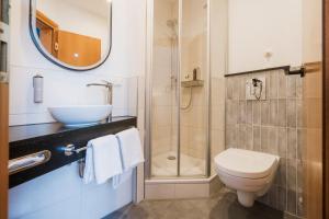 a bathroom with a toilet and a sink and a shower at Hotel Das Lola in Essen +44 photos