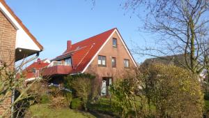 a large brick house with a red roof at Haus Kathrin in Büsum