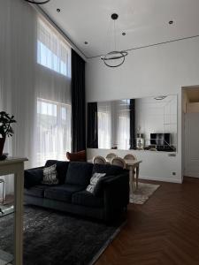 a living room with a black couch and a table at LouLou Hills in Uchastkovoyye Khozyaystvo SKhI