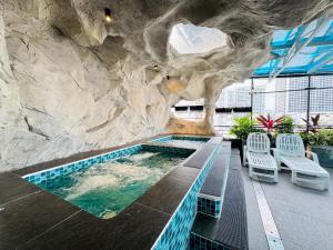 a swimming pool with a rock wall next to a building at Jolia Nha Trang Hotel in Nha Trang
