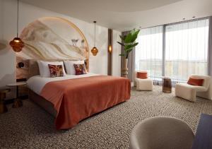 a bedroom with a large bed and a large window at Van der Valk Hotel Nuland - 's-Hertogenbosch in Nuland