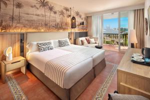 a bedroom with a large bed and a living room at Esencia de Fuerteventura by Princess in Playa Jandia