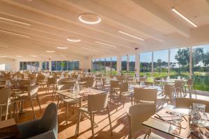 a banquet hall with tables and chairs and windows at Caladune Resort in Pizzo